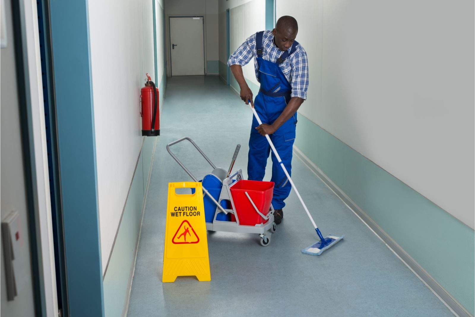 Clean 2 the korea staff mopping school hallway with cleaning cart and wet floor sign